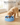 Golden retriever puppy eating from the blue slow feeder bowl on a wooden floor