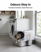 Cat using the large hooded stainless steel litter box in a laundry