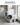 Cat using the large hooded stainless steel litter box in a laundry