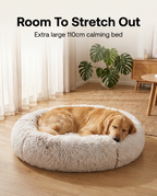 Large dog curled asleep in the 110cm calming plush pet bed