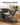 Small dog climbing the three step grey foam pet stairs to a sofa